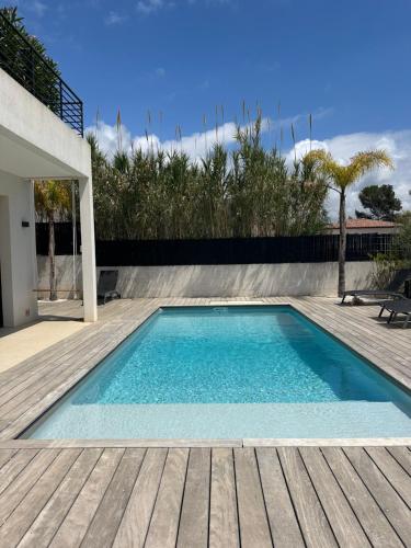 een zwembad op een houten terras naast een huis bij Villa Clara chambre double in La Ciotat
