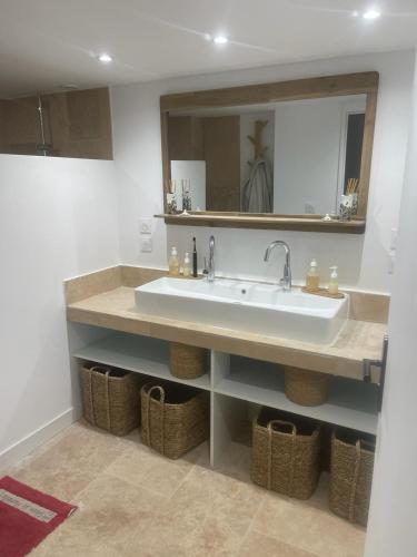 La salle de bains est pourvue d'un lavabo, d'un miroir et de paniers. dans l'établissement Villa close to Calanques, à Marseille