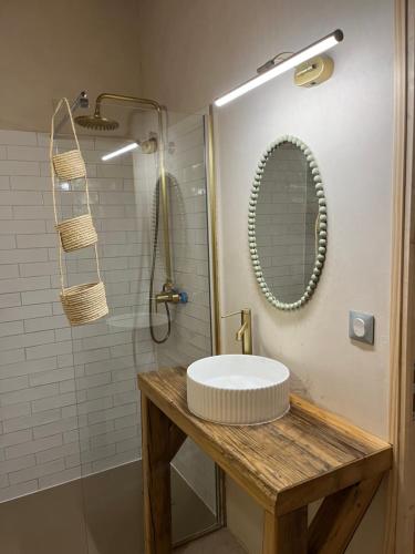 une salle de bain avec un lavabo et une douche avec un miroir dans l'établissement Gite à la campagne, à Mézières-sous-Lavardin