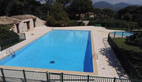 a large blue swimming pool in a yard at Maison LouLou in Cogolin