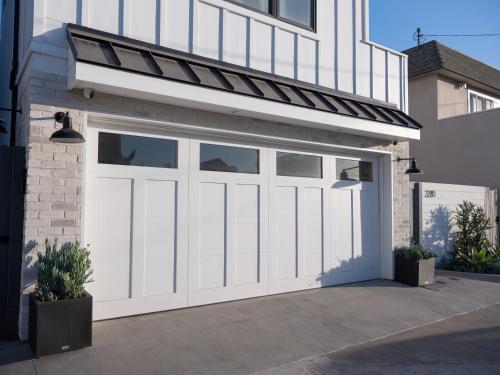 a garage with white doors on a house at Harbor Lookout - Luxury Beach Home with Coastal Views - Walk to everything! in Newport Beach