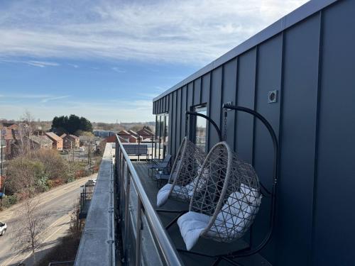 two chairs on a balcony with a view of a street at Luxury York Minster Penthouse - Free Gym & Parking in York