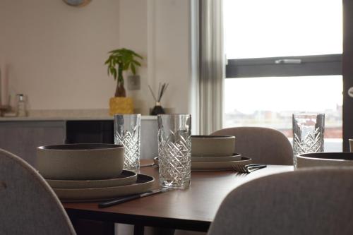 a table with plates and bowls and glasses on it at Luxury York Minster Penthouse - Free Gym & Parking in York