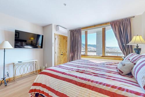 Un dormitorio con una cama grande con una ventana grande. en Torian Plum Creekside 516, en Steamboat Springs
