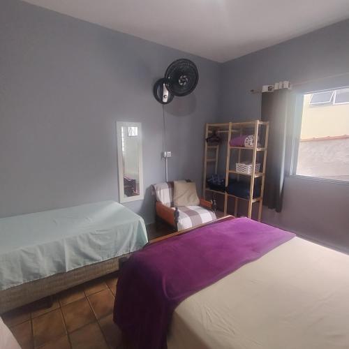 a bedroom with two beds and a window at Suite confortável no centro com Wi fi e TV a Cabo in Águas de São Pedro