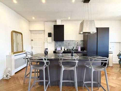 une cuisine avec un comptoir et des tabourets. dans l'établissement Essence des Carmes - T3 en hyper centre et climatisé, à Toulouse