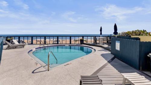 a swimming pool with a view of the ocean at Ocean Oasis - Ocean View At Symphony Beach Club in Ormond Beach