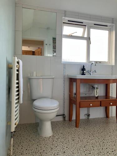 a bathroom with a toilet and a sink and a window at Homely holiday house in central Sevenoaks in Kent