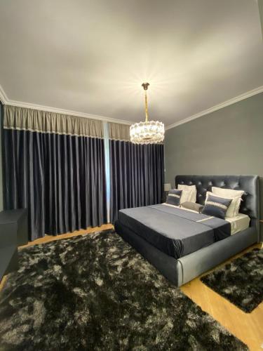 a bedroom with a bed and a chandelier at LY Studio Pipera in Voluntari