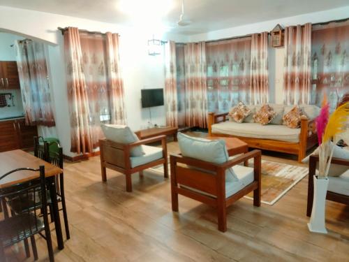 un salon avec un canapé et des chaises dans l'établissement Pearl Homes, à Ukunda