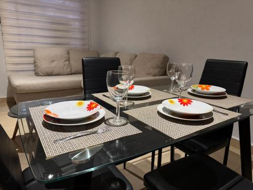 a dining room table with plates and wine glasses at Casa Mar y Laguna PUERTA AL SOL in General Juan N Alvarez International Airport