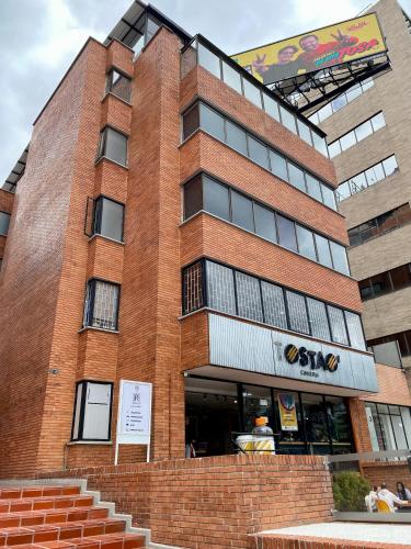 a tall brick building with a sign on it at Ope Suites calle 100 in Bogotá