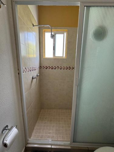a shower with a glass door in a bathroom at Casa Mar y Laguna PUERTA AL SOL in General Juan N Alvarez International Airport