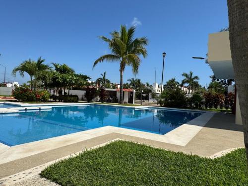 a large swimming pool with palm trees in the background at Casa Mar y Laguna PUERTA AL SOL in General Juan N Alvarez International Airport