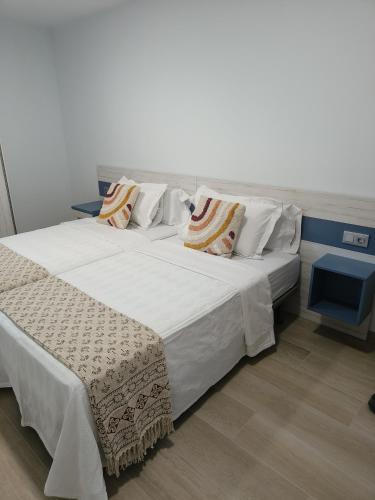 a bedroom with two beds with white sheets and pillows at Quirós Villa Tranquila de Salcedo 1 in La Villa