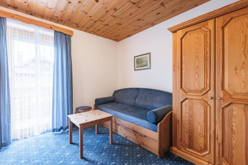 a living room with a blue couch and a table at Garni Hotel Berc in Bled