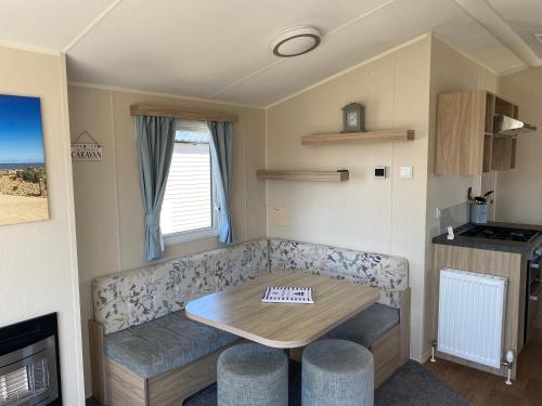 a living room with a couch and a table in a caravan at Karen's Caravan in Great Yarmouth