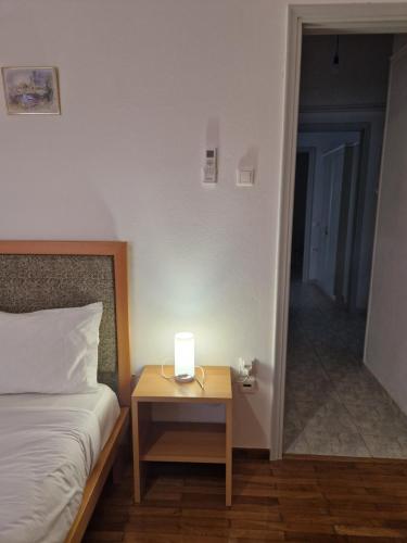 a bedroom with a bed and a night stand with a candle on it at EstellApartments in Athens