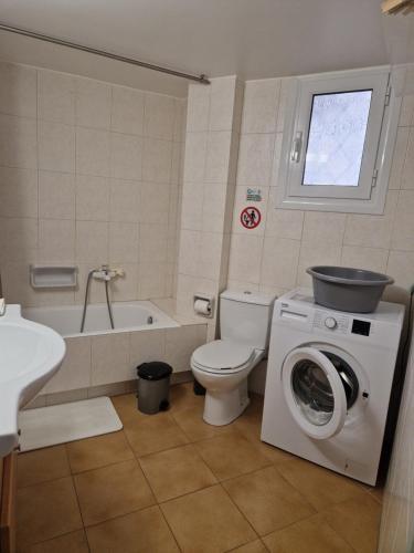 a bathroom with a toilet and a washing machine at EstellApartments in Athens
