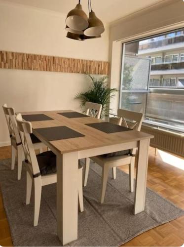 a wooden table and chairs in a room with a window at Hasselita in Hasselt