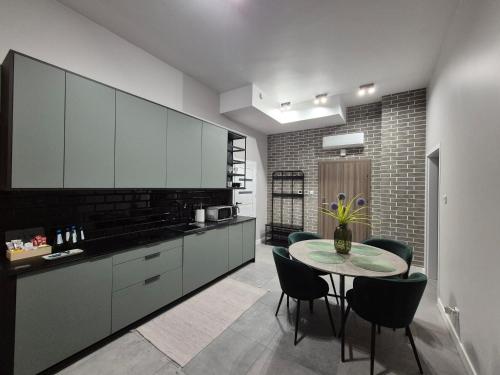 a kitchen with a table and chairs in a room at APARTAMENTY PRUCHNICKA in Jarosław