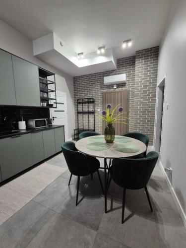 a dining room with a table and chairs in a kitchen at APARTAMENTY PRUCHNICKA in Jarosław