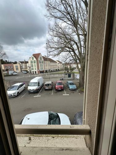 - une vue sur un parking avec des voitures dans l'établissement Studio meuble coquet et zen, à Denonville