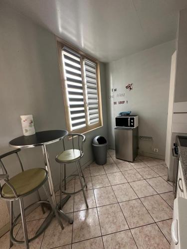 une cuisine avec une table et des chaises dans une pièce dans l'établissement Studio meuble coquet et zen, à Denonville