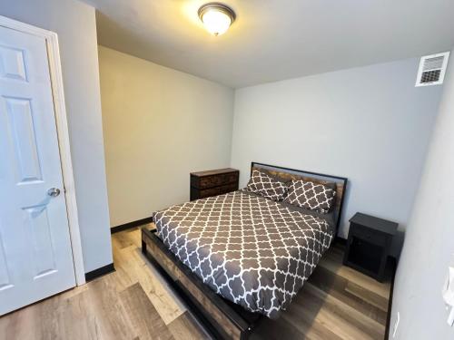 a bedroom with a bed and a white wall at COZY 2BR Apartment near Downtown DC in Washington, D.C.
