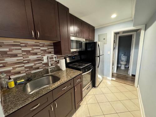a kitchen with a sink and a refrigerator at COZY 2BR Apartment near Downtown DC in Washington, D.C.