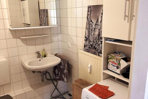 a small bathroom with a sink and a mirror at Apartment near trade fair, rhine and city in Cologne
