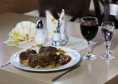 a plate of food on a table with a glass of wine at Pension Ferienhof Fischer in Freiberg