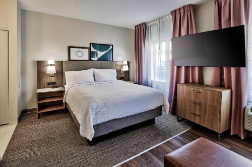 a hotel room with a bed and a large window at Staybridge Suites - Albuquerque Airport by IHG in Albuquerque