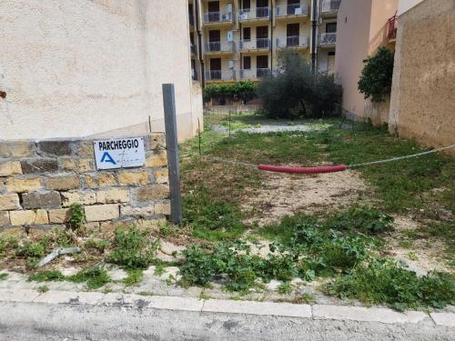 a street sign on a rope next to a building at Atrium in Castellammare del Golfo
