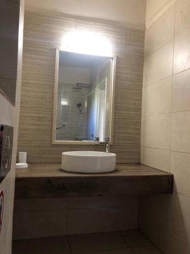 a bathroom with a sink and a mirror at Poseidon Apartments in Ayia Evfimia