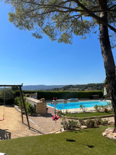 Une balançoire est installée dans une cour avec une piscine. dans l'établissement Grande Villa avec Piscine, Pétanque et Vue Mer pour 12 Personnes, au Beausset