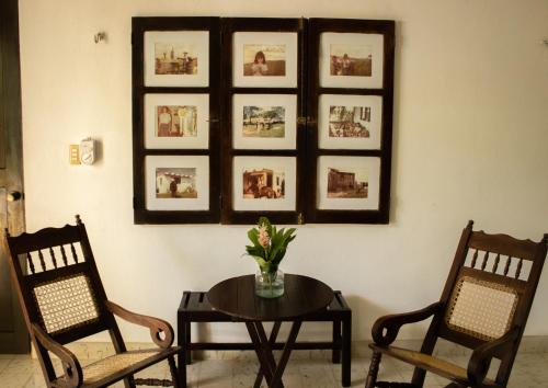 a room with two chairs and a table with flowers at El Prado- Rancho familiar en Yucatán in Xocchel