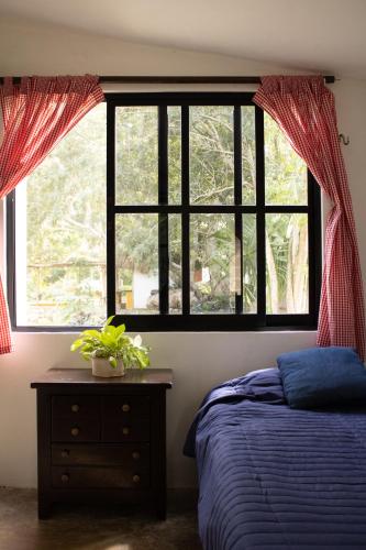 a bedroom with a bed and a window at El Prado- Rancho familiar en Yucatán in Xocchel