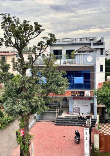 a building with a tree in front of it at Hotel Tulsi Inn in Haldwāni