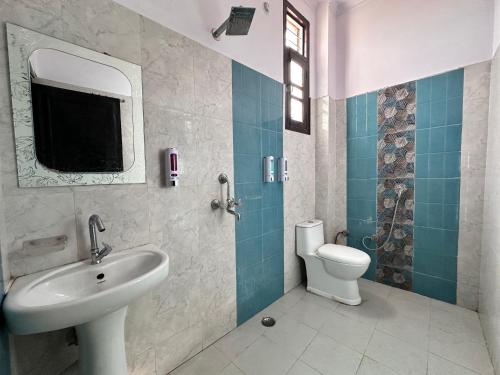 a bathroom with a sink and a toilet at Hotel Tulsi Inn in Haldwāni