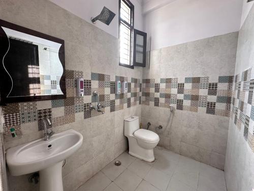 a bathroom with a toilet and a sink at Hotel Tulsi Inn in Haldwāni