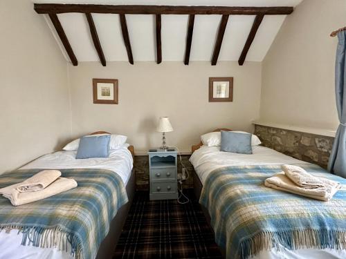 two twin beds in a room with a roof at Bilsdale Cottage in Helmsley