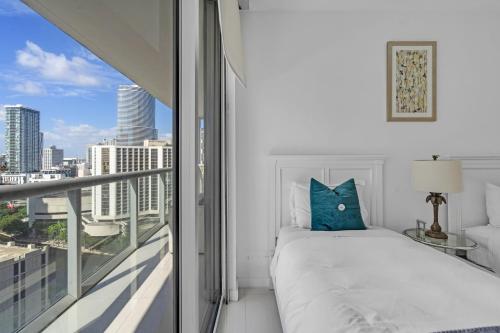 a white bedroom with a bed and a balcony at Moderne 2 bed 2 bath Residence in Miami