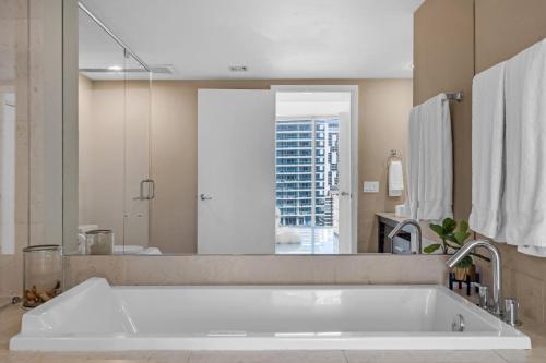 a large white tub in a bathroom with a large mirror at Moderne 2 bed 2 bath Residence in Miami