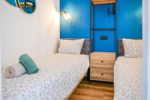 deux lits dans une chambre aux murs bleus dans l'établissement Bel appartement vue mer - quartier des Présidents - 5 personnes, à Les Sables-dʼOlonne