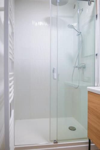 une douche avec une porte vitrée dans une salle de bain dans l'établissement Bel appartement vue mer - quartier des Présidents - 5 personnes, à Les Sables-dʼOlonne