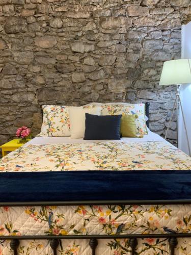 a bed in a room with a stone wall at City Center Luxurious Studio in Praia