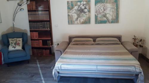 a bedroom with a bed and a blue chair at Garibaldi 15 in Marsala