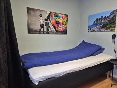 a bed in a room with a poster on the wall at Senja 4 Summit in Torsken