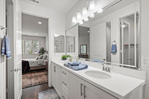 Un baño con lavabo y un espejo grande. en Gorgeous Family Home, Close to Frwys, Hospitals & Sports Arenas, Pets OK, en Orange